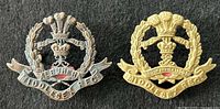 Front view of both Middlesex Regiment cap badges side by side