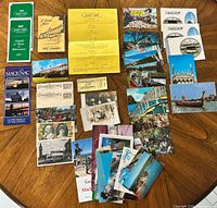 Full layout of menus, brochures, postcards, medal and paper pieces on table