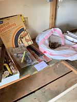 Shelf with Norton sanding cloth, packaged accessories, bag of brass hardware