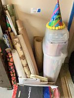 Lot overview showing wrapping paper rolls, storage tube, gift bags and party hat