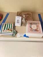 Overview showing all items: boxed card set, Donna playing cards, Jewel Key, wire stand, loose cards, decorative box
