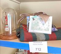All items together: plaid throw, snowman ornament in dome, Christmas card frame, ribbon, gift box