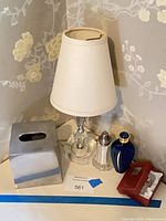 Group shot showing lamp with shade, tissue box cover, shaker, perfume bottle, red box