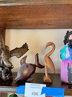 Wide shot showing all three carved wooden figures on shelf