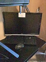 Dell monitor with keyboard and mouse on desk