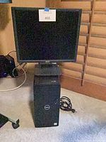 Dell desktop tower with Acer monitor stacked, power cable visible