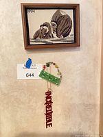 Overall view showing framed needlepoint, green plaque with beads, red wooden letters