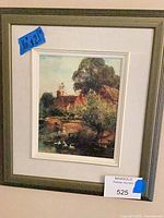 Front view of framed print on wall showing full item with tape label 16x21 and auction tag