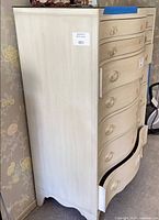 Full view of cream wood tall chest dresser with six drawers, shows bottom drawer misaligned