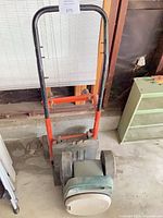 Upright hand truck and plastic rolling scooter visible together