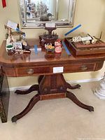 Full view of mahogany pedestal console table with drawer and pedestal base