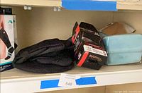 Shelf view showing lumbar brace box, black fabric items, teal knee pillow