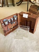 Open bar case showing interior wood compartments, stainless cups, bar tools and acrylic caddies