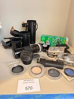 Overall lot showing camera, lens, adapter, filters, film pack, lens cases and grip