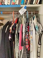 Clothing on hangers showing variety of garments and colours