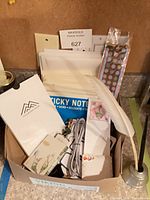 Box containing assorted stationery, cable, bookmarks, quill pen