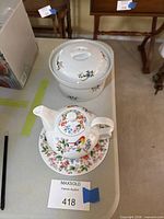 Tea-for-one set stacked on saucer and round covered casserole bowl