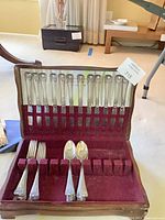 Open flatware case showing all knives, forks, spoons