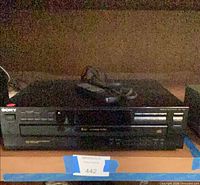 Front view of Sony CD changer showing disc tray, buttons and brand logo