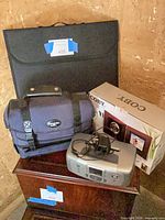 Group shot showing camcorder bag, photo frame box, printer, lighting studio case
