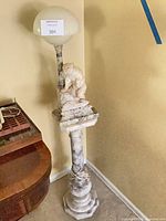 Full view of marble/alabaster floor lamp showing base, column, carved animal, globe shade, wiring