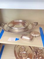 Top shelf showing tray, chafing dish components, butter dish and shell dish