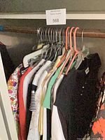 Row of assorted women’s tops on hangers showing variety of colors and styles