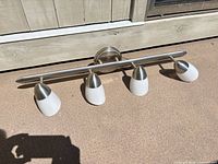 Overall view of the four-light brushed nickel vanity fixture with frosted shades