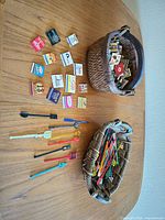 Overall view showing two baskets, loose matchbooks and stir sticks on table