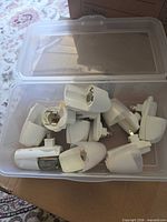 Open plastic bin containing several white Air Wick plug-in housings