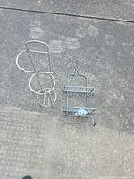 freestanding toilet paper holder and folded shower caddy on ground