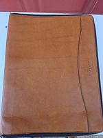 Front view of tan leather folio showing overall condition and zipper