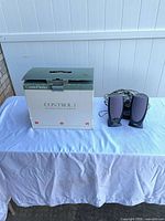 Speakers with wires and original box on table