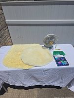 All five items on table: fan, LED strip box, broom, two shag rugs
