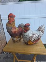 Rooster and hen stuffed figures side by side on table