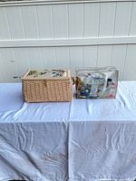 Wicker sewing basket and clear vinyl pouch side by side on table