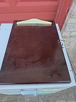 Closed wooden clipboard box showing dark mahogany top and cord tie