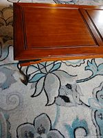 Corner close-up showing metal leg, stretcher, and wood finish wear