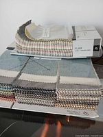 Stacked sample books showing multicolour swatch deck on Avant Garde Flax and Piccadilly books