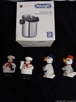 Boxed DeLonghi coffee knock-out box with four ceramic pieces laid out