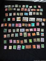 Full view of 90 loose stamps laid out on black background