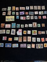 Full layout of 70 assorted international stamps on black background