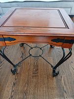 Full view of side table showing wood top, metal legs, stretcher