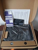 Box opened showing wrapped TELUS T3200M unit with manuals and stickers