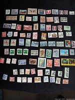 Overall view of roughly 90 mixed stamps laid out
