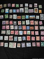 Full view of approximately 80 worldwide stamps on black background