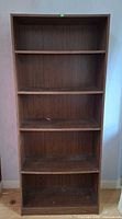 Front view of entire brown bookcase with four shelves