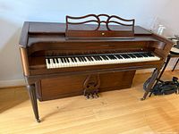 Full front view of Baldwin Acrosonic spinet piano showing keys, music rack, pedals
