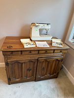 cabinet with sewing machine, accessories on top