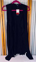 Full front view of black sleeveless ribbed vest on hanger with tag visible